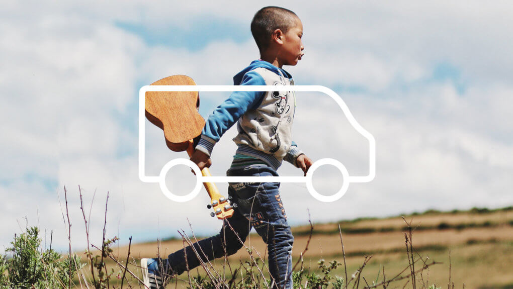 kid running in a field holding a ukulele, with an overlay of a van icon