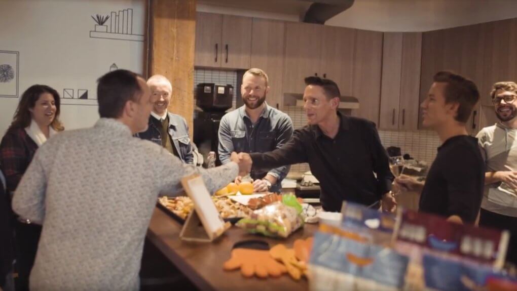 Members from the Little Potato Company shaking hands with members from Major Tom over food
